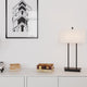 Bordlampe Luton hvit på et moderne bord med bøker og et kunstverk i bakgrunnen.