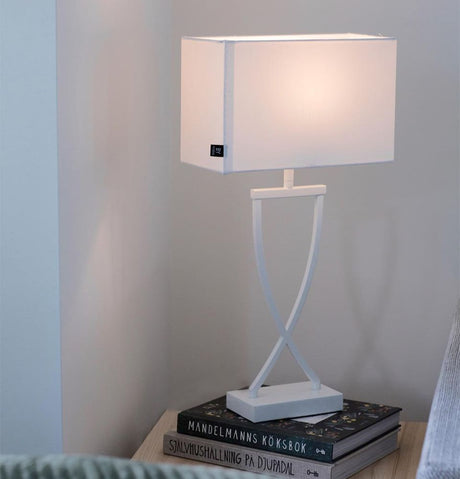 Lampada da tavolo Omega 52 cm in bianco su un tavolo con libri, design elegante e dimensioni perfette per ogni ambiente.