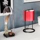 Bordlampe Vieste 45 cm med rød fløyelsskjerm ved siden av en glasskuppel med fjær og fuglemotiv.