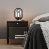 Stilvolle Tischleuchte Leola aus Rauchglas auf Nachtisch, modern und harmonisch in einem Schlafzimmer. By Rydens.