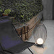 Cage Outdoor LED Terrassenlampe IP65 Anthrazit neben einem Liegestuhl im Außenbereich.