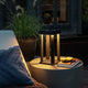 Cannes Outdoor USB-Laterne IP54 in Schwarz auf einem Tisch, dimmbar mit warmem Licht, perfekt für den Außenbereich.