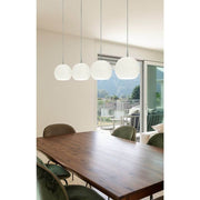 Casablanca dining table lamp Ball 4-light above a wooden table in a modern interior with a view of nature.