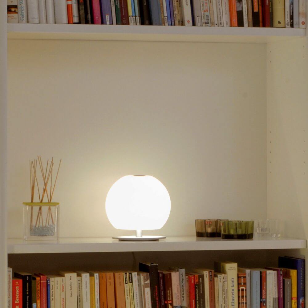 Casablanca Tischleuchte Ball Mini auf einem Regal mit Bücher und Dekoration, sorgt für stimmungsvolles Licht.
