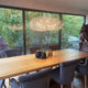 Modernes Esszimmer mit Catellani & Smith Fil de Fer Nuvola LED Hängeleuchte und eleganten grauen Stühlen.