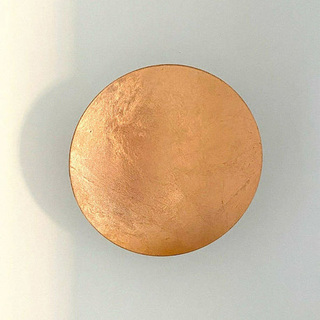 Runde, kupferfarbene Wandlampe von Catellani & Smith, elegant und minimalistisch, ideal für moderne Innenräume.