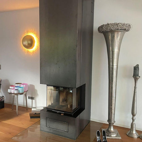 Catellani & Smith PostKrisi W 40 LED applique murale Ø 40 cm à côté d'une cheminée moderne dans le salon.