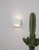 Chez LED Außenwandleuchte Oval 3000K Weiß IP54 an einer Wand neben einem Kaktus.