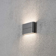 Chieri LED Außen-Wandleuchte Anthrazit, opales Acrylglas an einer grauen Wand montiert.