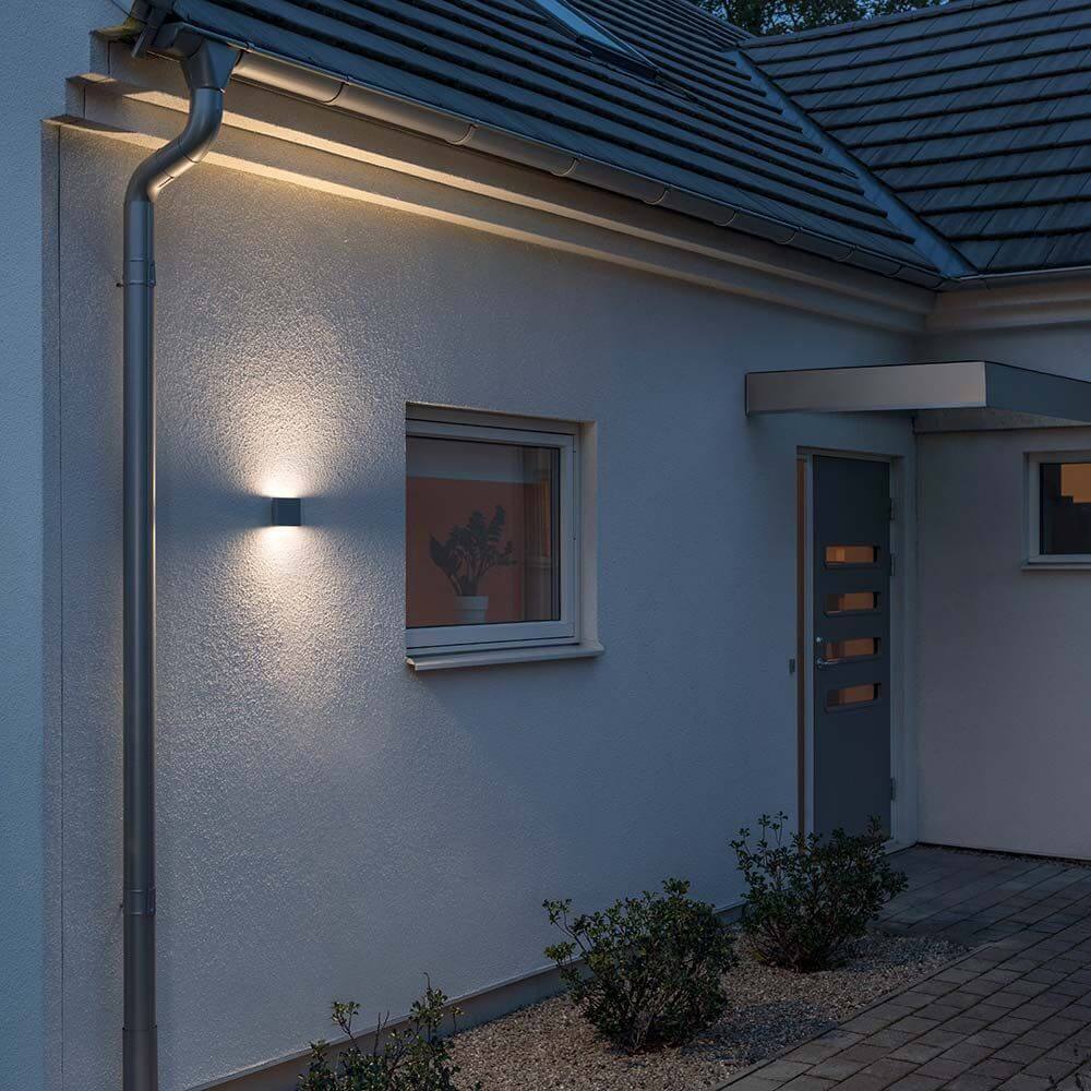 Chieri LED Außen-Wandleuchte Anthrazit, opales Acrylglas an einer Hauswand in der Dämmerung.