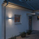 Chieri LED Außen-Wandleuchte Anthrazit, opales Acrylglas an einer Hauswand in der Dämmerung.