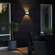 Moderne Chieri LED Außen Wandleuchte IP54 an schwarzem Außenwand mit stimmungsvollem Lichtdesign.