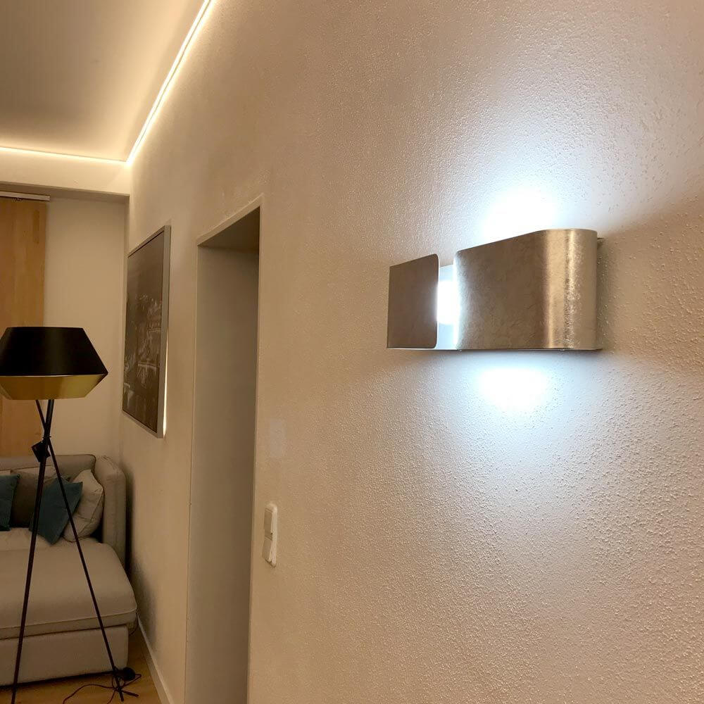 Clip Wandleuchte Up&Down 44cm Blattsilber an einer Wand in einem modernen Wohnraum.