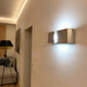 Clip Wandleuchte Up&Down 44cm Blattsilber an einer Wand in einem modernen Wohnraum.