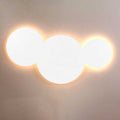 s.luce Cloud LED Wandleuchte mit drei kreisförmigen Elementen und warmem Licht auf grauem Hintergrund.