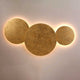 s.luce Cloud indirekte LED Wandleuchte mit goldenen runden Elementen und sanfter Beleuchtung.