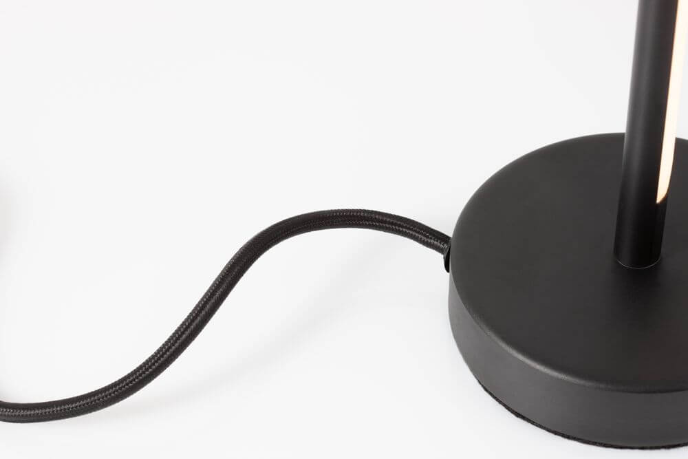Detailansicht der Colby LED Tischleuchte 3000K Schwarz mit schwarzem Kabel und Sockel.