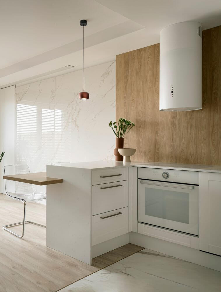 Moderne Küche mit Conga LED Pendelleuchte Ø 9,6cm 3000K über Holz- und Weißem Küchentisch.