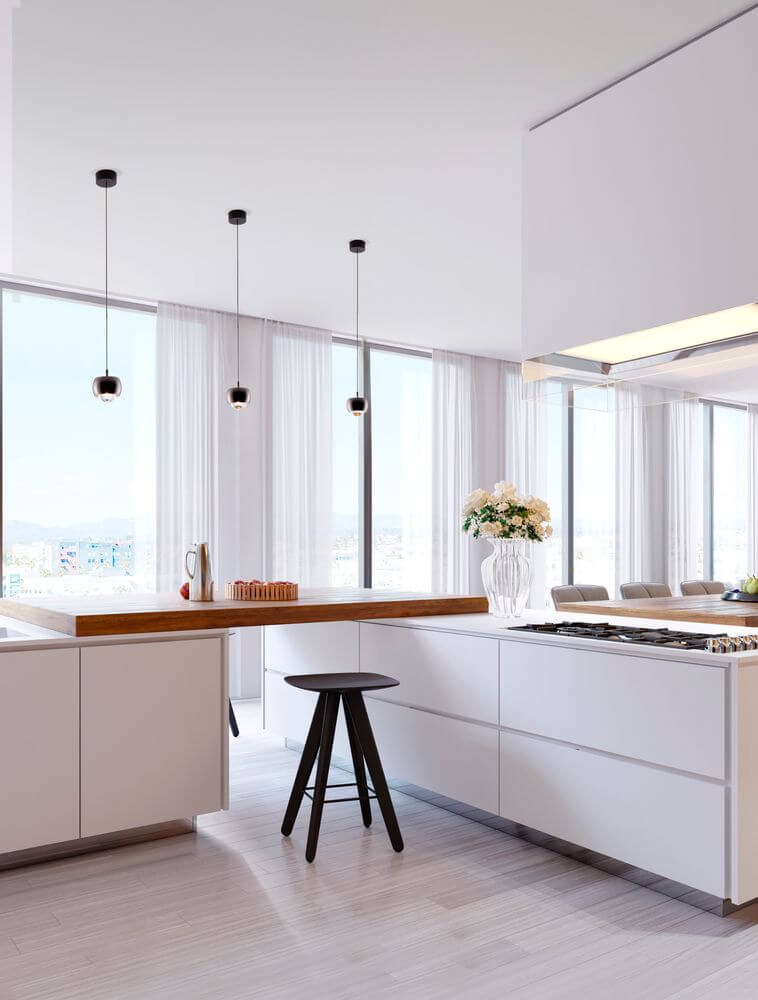 Moderne Küche mit Conga LED Pendelleuchte Ø 9,6cm 3000K über der Kücheninsel und stilvollem Holzarbeitsplatz.