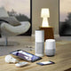 Moderne Smart-Home-Geräte auf einem Tisch: Lampe, Tablets und Sprachassistenten für die Heimautomatisierung.