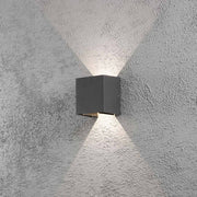 Lampa ścienna LED Cremona z regulowanym wypływem światła w kolorze antracytowym zamontowana na ścianie z promieniami światła