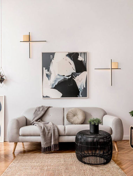 Kors LED Væglampe 50cm 2-pære 2700K på en lys stuevæg i sort og børstet guld finish over sofaen