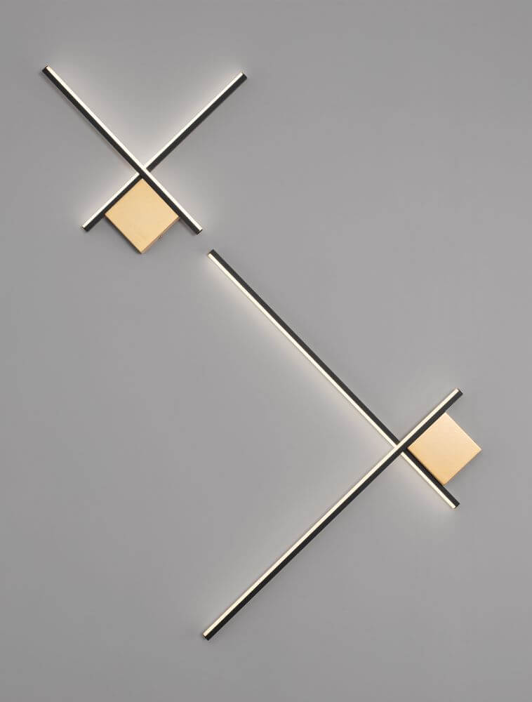 Cross LED Wandleuchte in mattem Gold mit geometrischem Design und spektakulären Lichteffekten.