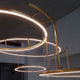 DCWéditions Broche LED Kronleuchter in Messing mit fließenden runden Formen und ätherischem Licht.