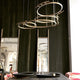 Moderne DCWéditions Broche LED Kronleuchter aus Messing, elegant über einem Tisch installiert.