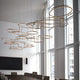 Moderne Messing Kronleuchter mit mehreren kreisförmigen LED-Lichtern in einem eleganten Raum.