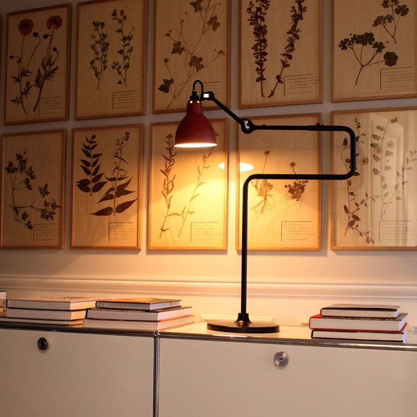 DCWéditions Gras N°317 table lamp with swiveling shade on a table, illuminated in an elegant room.