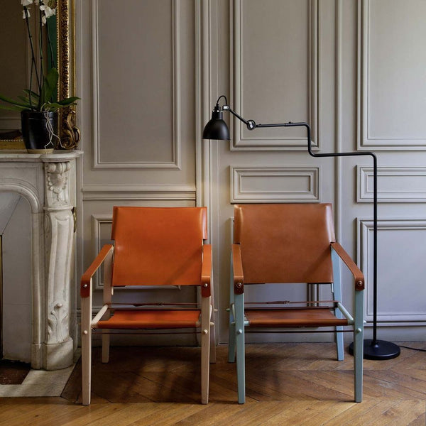 DCWéditions Gras N°411 floor lamp with swivelling shade next to two elegant leather armchairs.
