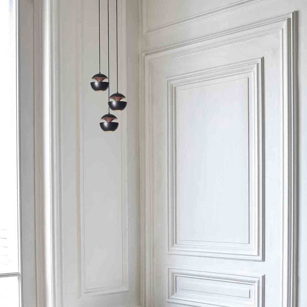 DCWéditions Here Comes The Sun Ø 10cm Mini LED pendant light in a modern room design with elegant wall cladding.