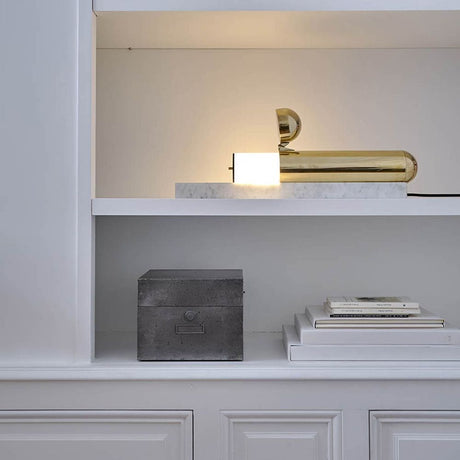 DCWéditions Isp LED Tischleuchte mit Marmorfuss auf einem Regal, modernes Design mit Lichtquelle.