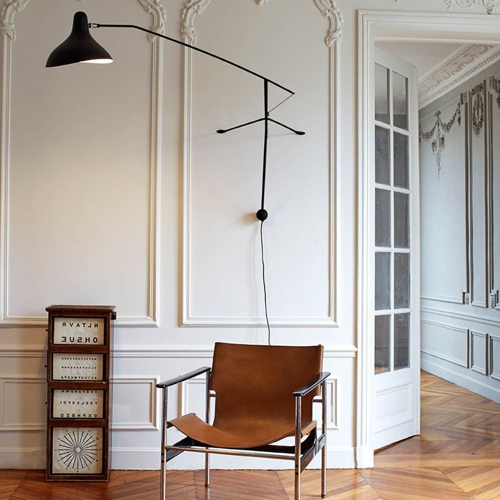 DCWéditions Mantis BS2 Wandleuchte mit Ausleger über einem Sessel in elegantem Raumdesign