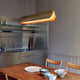 DCWéditions Respiro LED Pendelleuchte 90cm in moderner Kücheneinrichtung mit Holzstühlen und Geschirr.