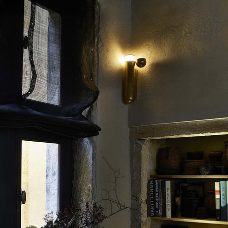 DCWéditions ISP LED-vegglampe i messing på veggen i et moderne rom.