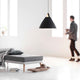 Pendellampe Strap 68 Schwarz über einem modernen Sofa in einem hellen Raum mit großen Fenstern.