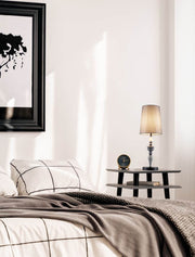 Lampe de table Damo Ø 22 cm gris, marron sur une table de chevet dans une chambre au décor moderne.