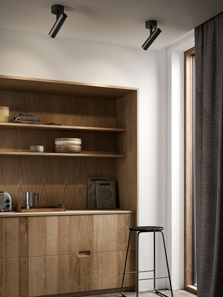 Taklampe MIB i moderne rom med trehylle og stol.