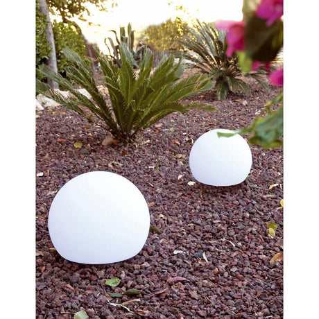 Dekokugel Ø 40cm BALDA-P IP55 Weiß im Garten, weißer Deko-Stein auf Kiesboden mit Pflanzen im Hintergrund.