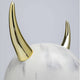 Design Tischleuchte Horn mit goldenen Hörnern auf einem weißen, marmorierten Lampenfuß.