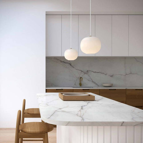 Navone Hängeleuchte Opal-Weiß über eleganter Kücheninsel mit Marmor und Holzdetails.
