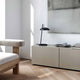 Versale Tischleuchte auf Sideboard in modernem skandinavischen Wohnraum mit minimalistischer Einrichtung.