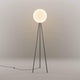 Moderne Stehlampe mit runder Glühbirne und schlankem Design in neutralem Raum