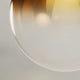 Nahaufnahme der Glaskugel der s.luce Dreibein-Stehleuchte Orb, die elegantes Licht ausstrahlt.