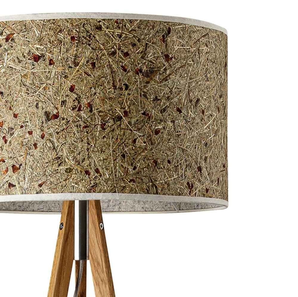 Dreibeinstehleuchte Ligno mit Holzfuß und natürlichem Lampenschirm in Almheu-Optik.