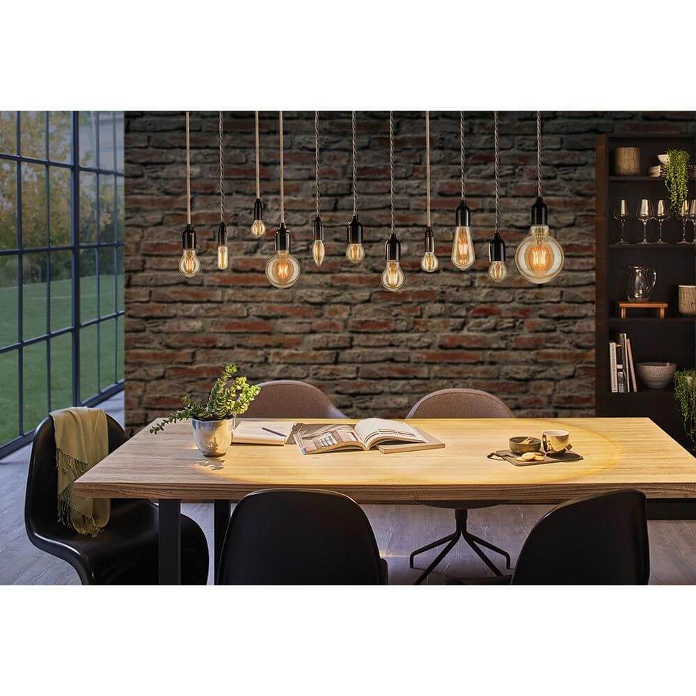 E27 4,7W Vintage Edition LED Tropfen 2500K Dimmbar, Gold in einem modernen Essbereich mit dekorativer Beleuchtung.