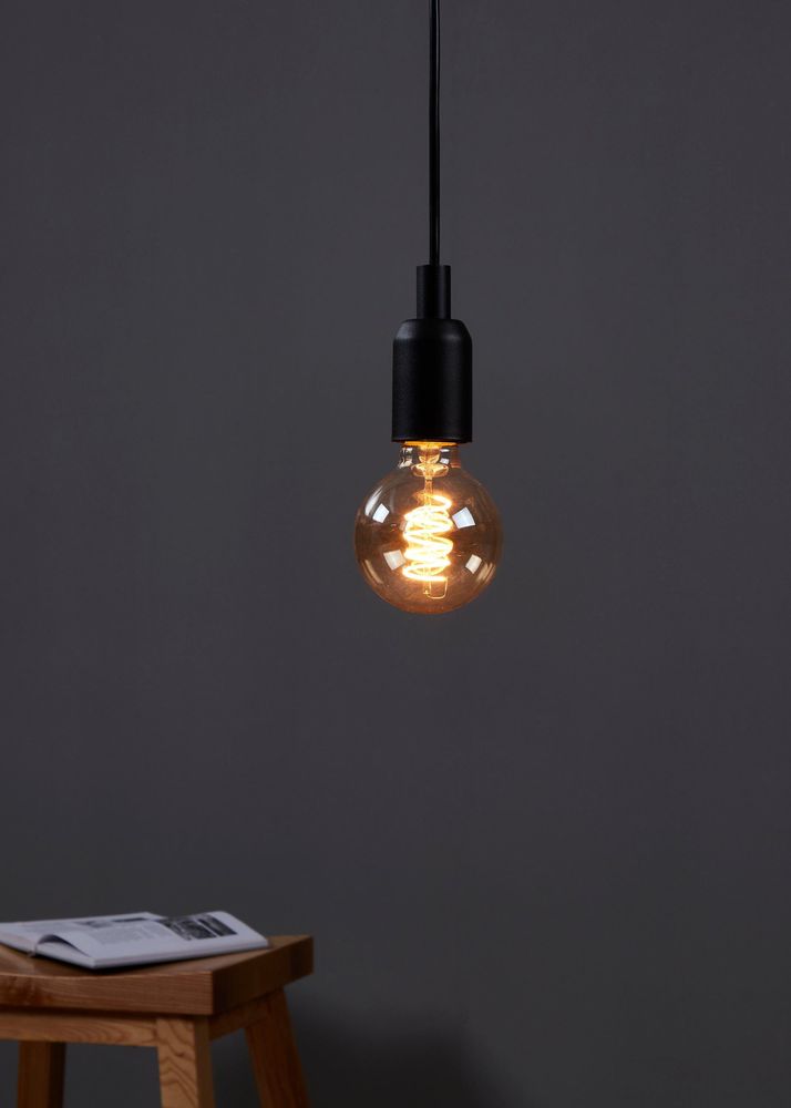 E27 LED Retro Globe mit extra warmweißem Licht, hängend in minimalistischer Umgebung.