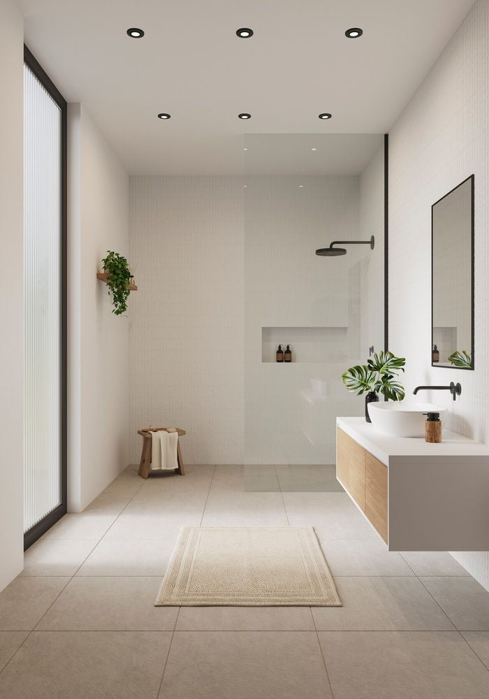 Helles Badezimmer mit Einbaustrahlern, moderner Duschkabine und minimalistischer Einrichtung.